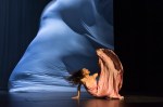 A dancer with billowing curtain behind